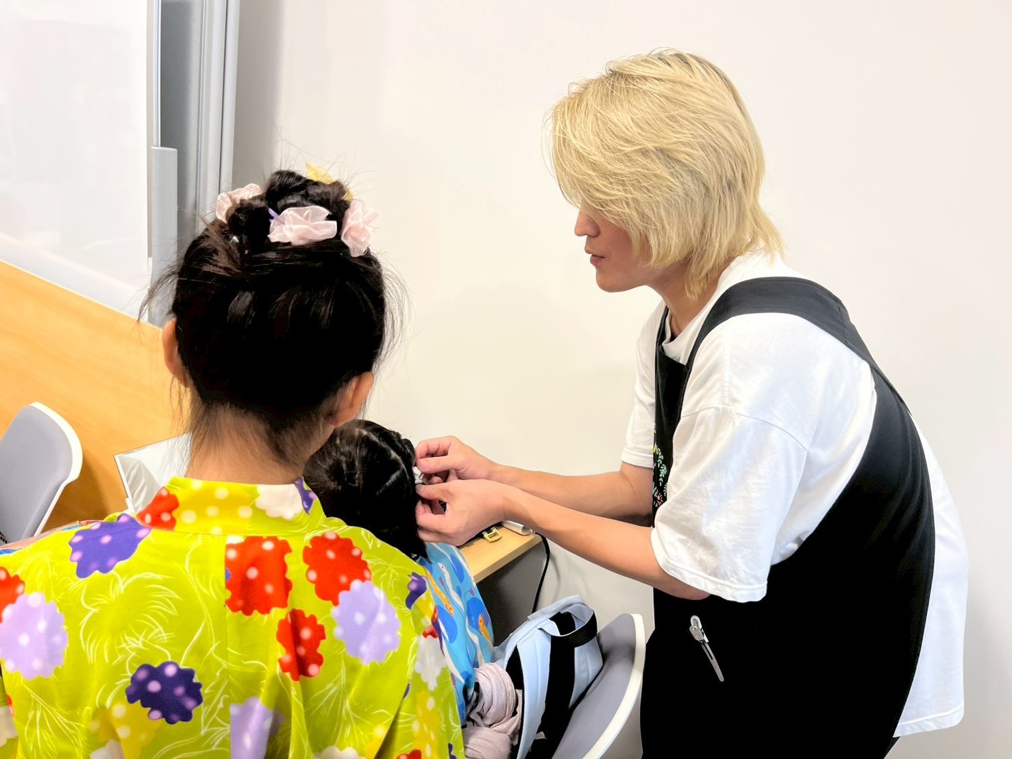 浴衣の子どもの髪を結うザッキー